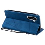 Blue leather folding phone case with geometric panel design and a triple-camera cutout, propped open as a stand