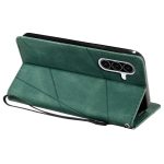 Green geometric leather phone case with built-in kickstand and wrist strap, shown from the back with a triple-camera cutout.