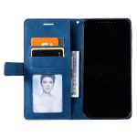 Blue leather wallet-style phone case opened to reveal card slots, cash, a photo ID, and a black smartphone adjacent to it.