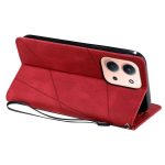 Red geometric leather phone case with built-in stand and wrist strap, angled to show the camera cutout on a smartphone.