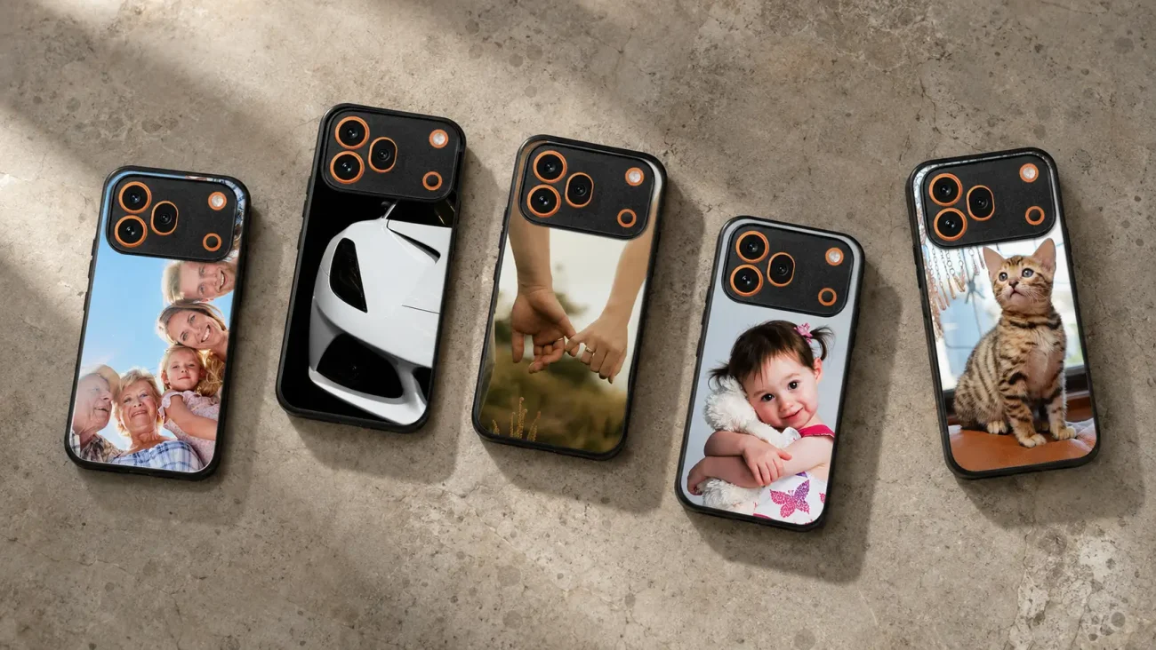 Five smartphones with personalized photo cases laid on a concrete surface, each displaying a different image (family portrait, white sports car, couple holding hands, smiling baby with a stuffed animal, and a cat).