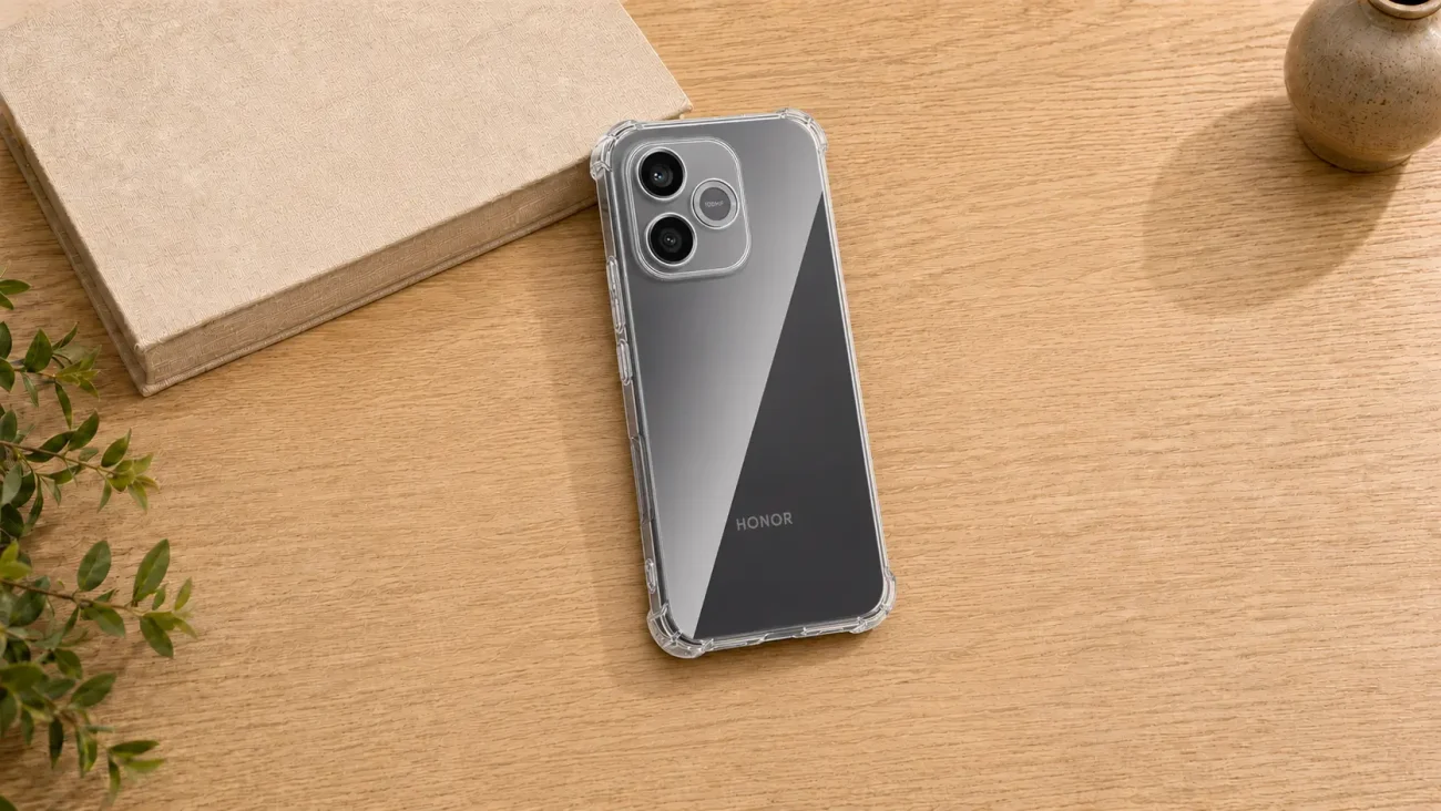 Prozorni Ovitki za Honor 600 Lite | Poceni-Ovitki.si Clear-backed HONOR smartphone in a protective case on a wooden desk near a beige notebook and a small plant.