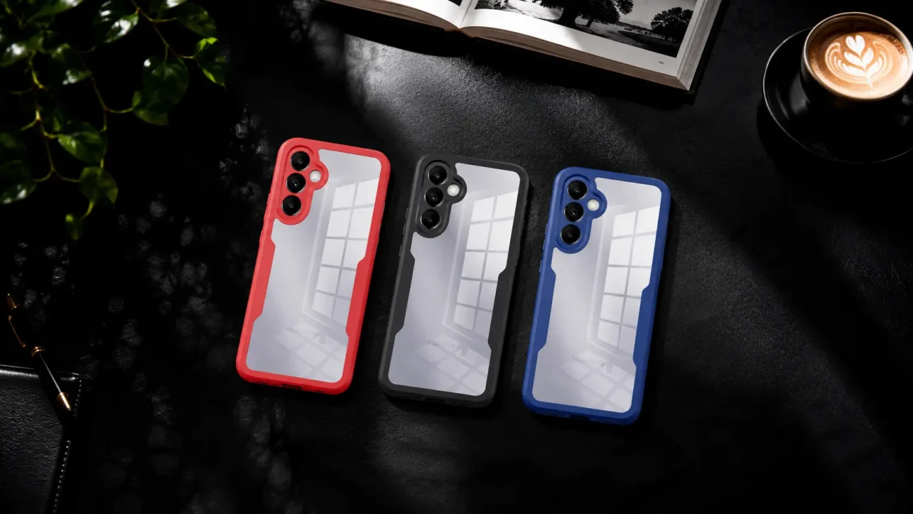 Three smartphone cases with red, black, and blue frames and clear backs laid on a dark surface.